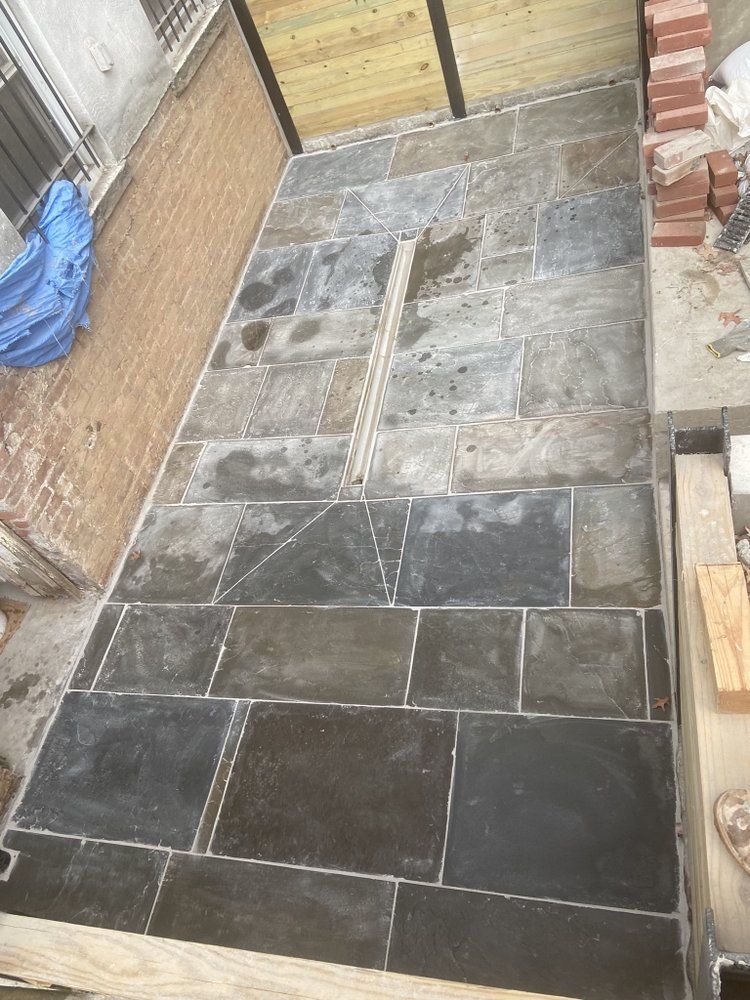 A brick walkway is being built in a backyard.