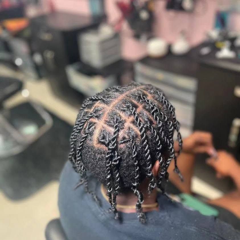 Close-up of braided hair with parts visible, viewed from above in a salon chair