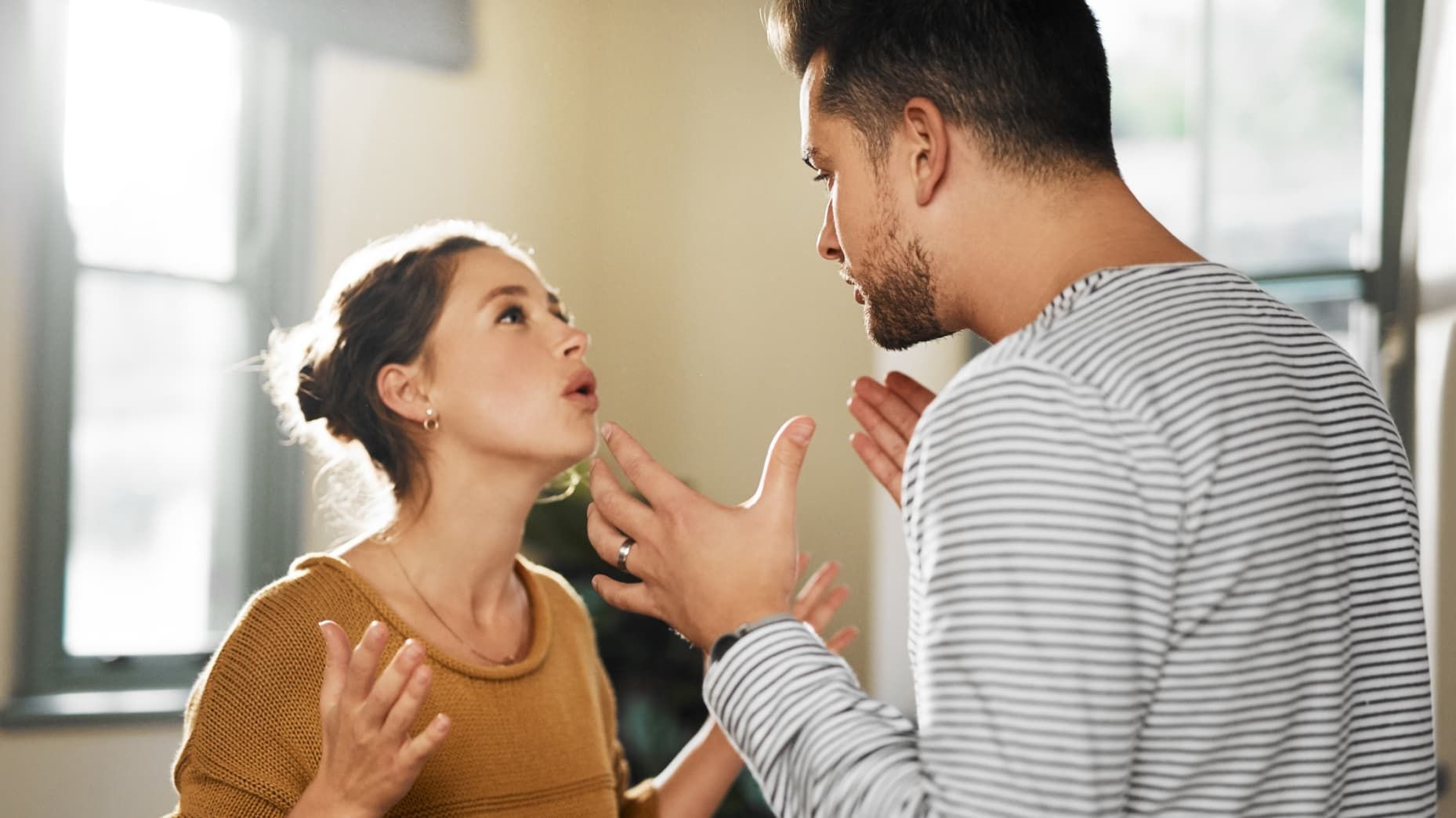 A man and a woman are having an argument in a living room.
