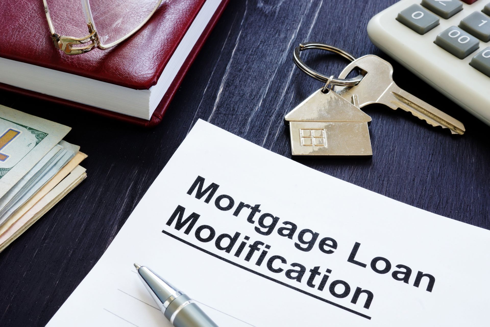 A mortgage loan modification form with a pen and keys