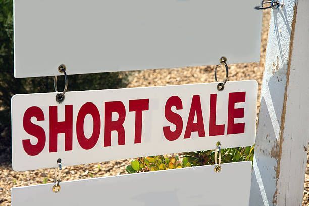 A white sign that says short sale on it