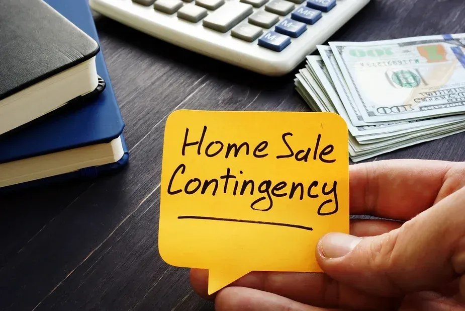 A person is holding a sticky note that says home sale contingency