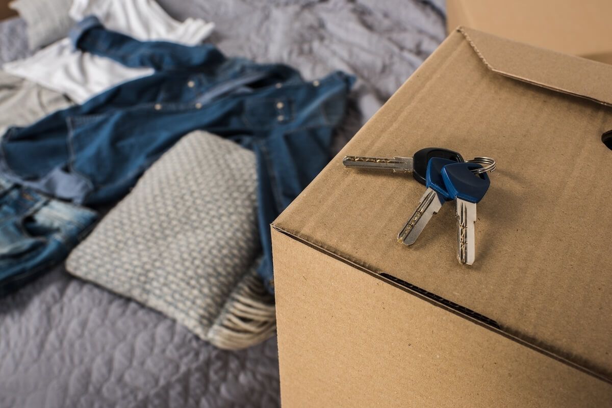 A cardboard box filled with clothes and a pair of keys.