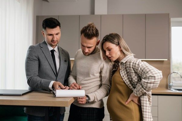 A man and a pregnant woman are looking at a piece of paper.