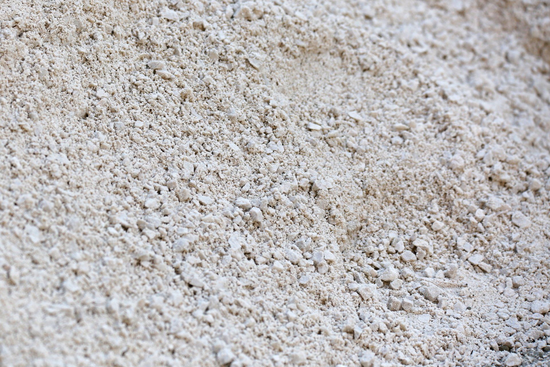 Close-up of pale beige granular sand or gravel texture