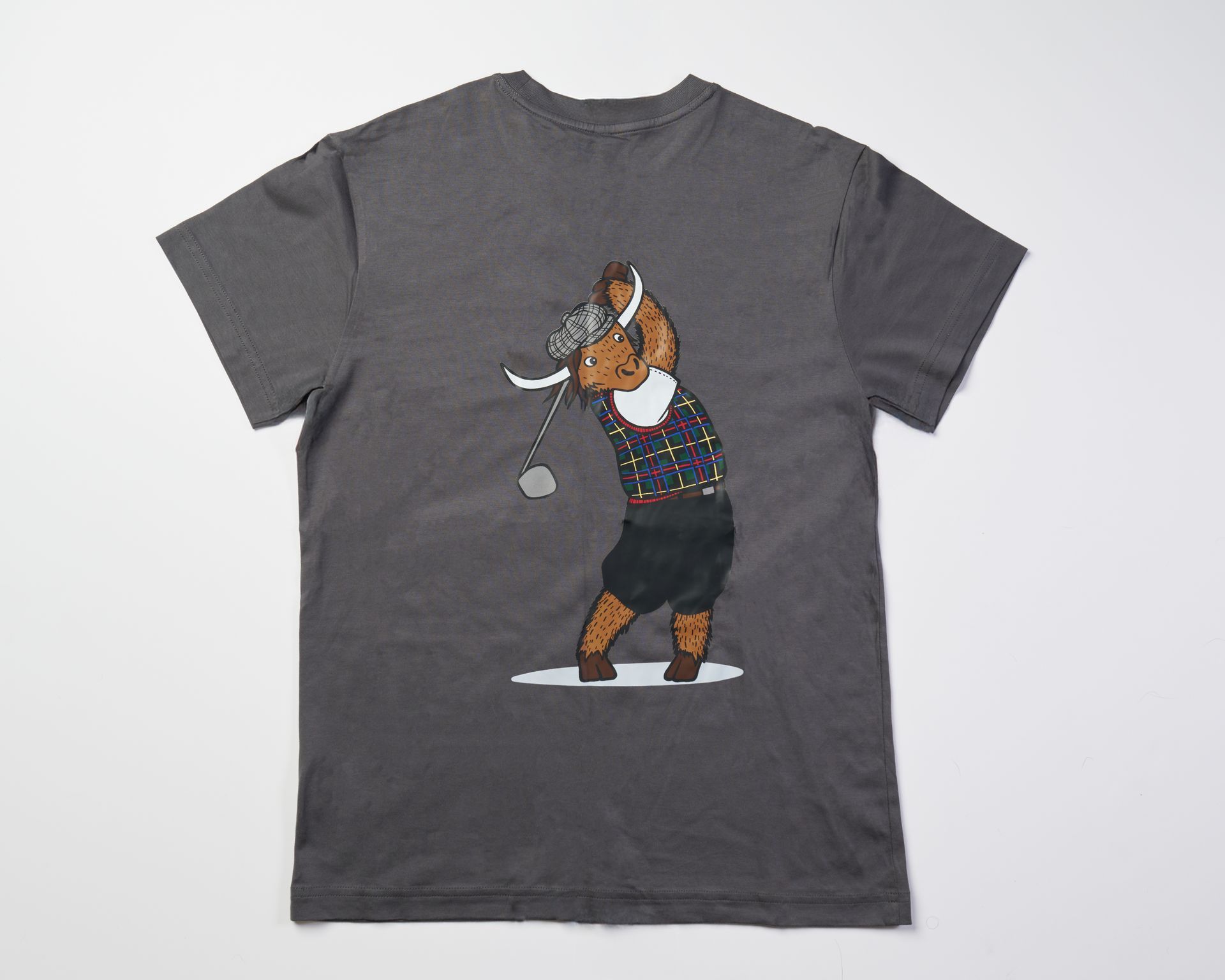 Golfer Guild SUPIMA® cotton Tartan Swinger tee with highland cow golfing animal art by Jonas Claesson.