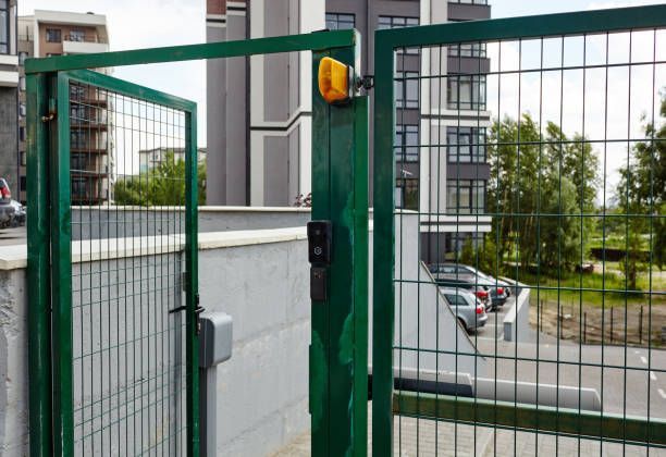 A Green Gate With A Yellow Light On It Is Open To A Parking Lot - Bolingbrook, IL - Master Locksmithing Inc