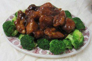 Chicken and broccoli dish in brown sauce on a plate with broccoli florets.