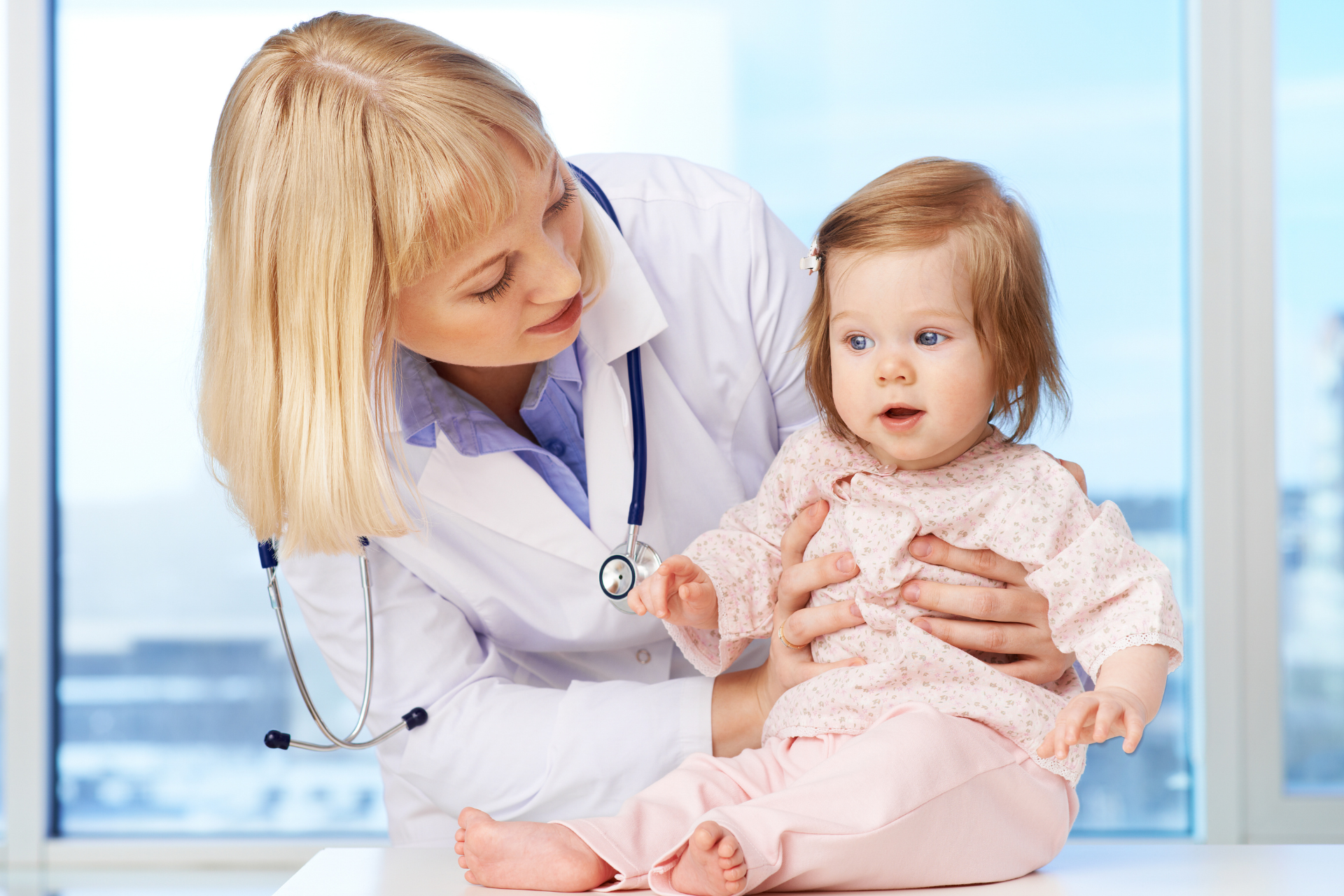 Doctor examining a baby on a medical table in a bright clinic