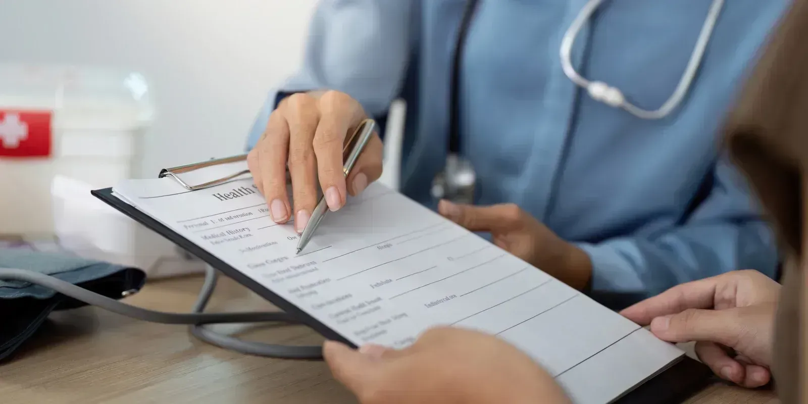 Doctor writing on a clipboard during a medical consultation
