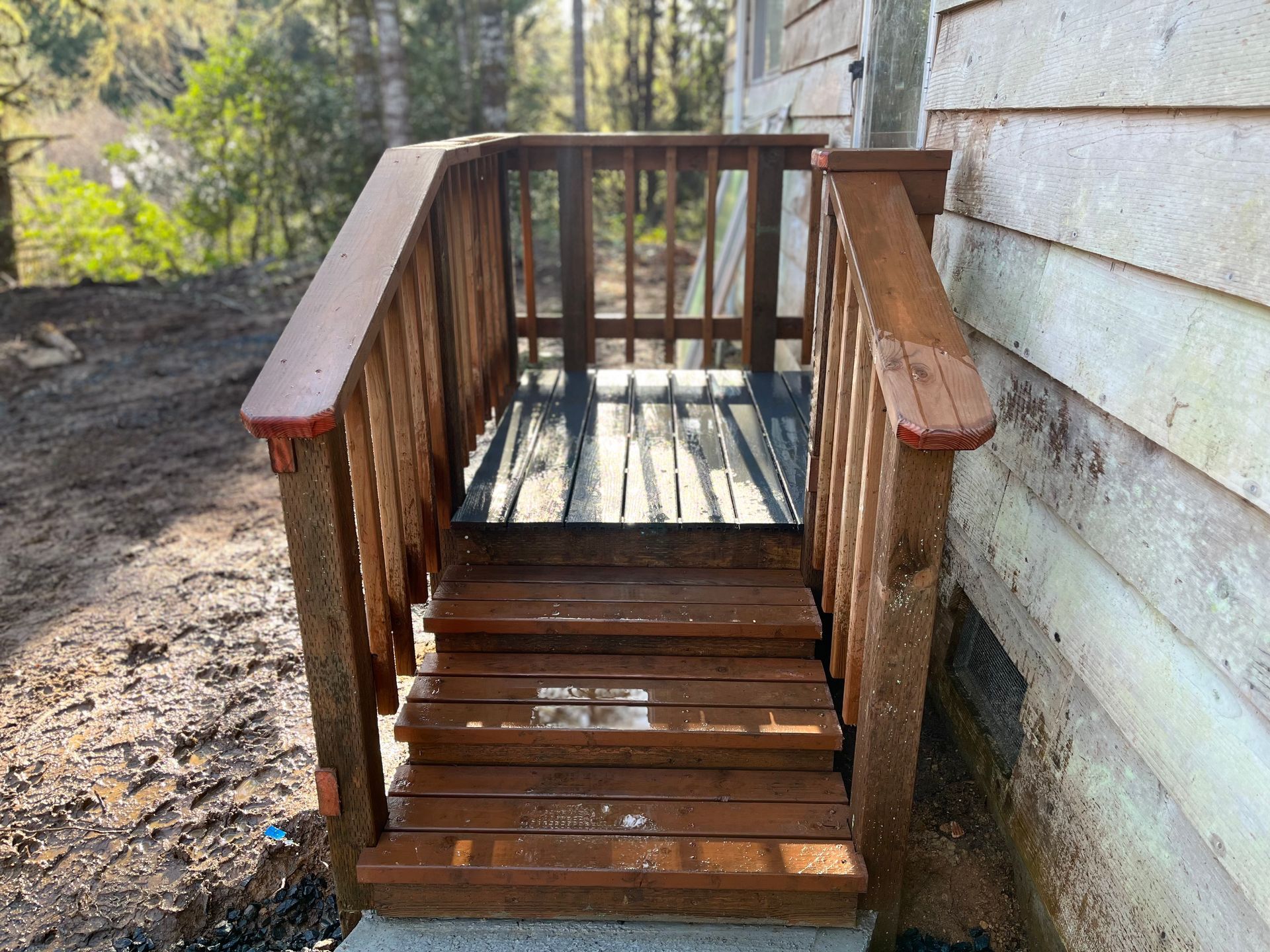 A wooden deck with stairs leading up to a house.