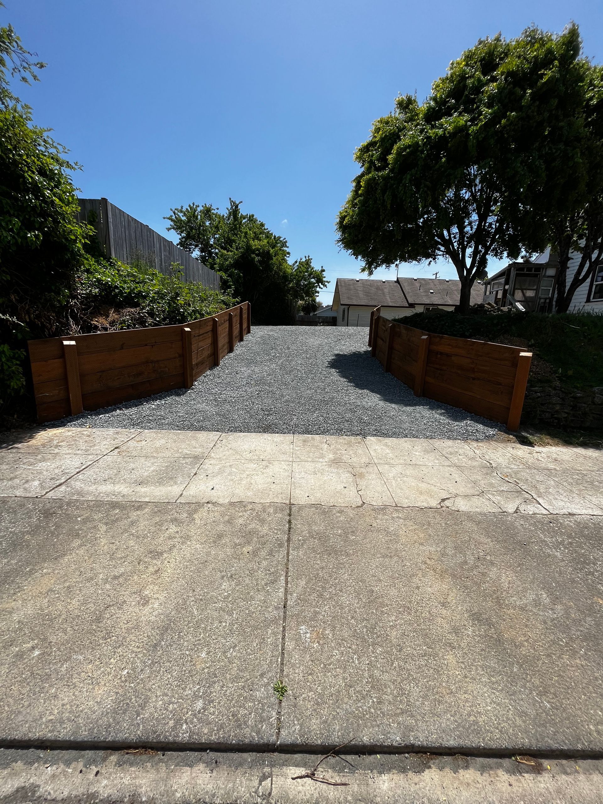 A gravel driveway leading to a house on a sunny day
