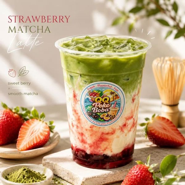 Strawberry matcha latte in a clear cup with strawberries and matcha powder on a light tabletop