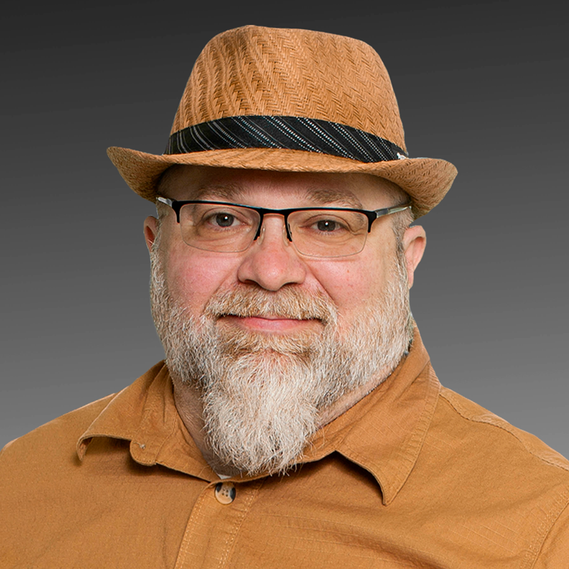 a man with a beard wearing a hat and glasses .