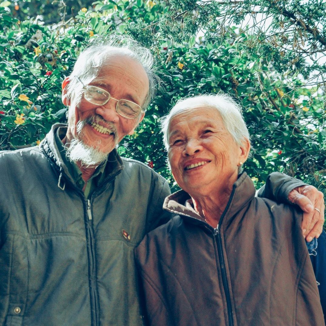 a man and woman are posing for a picture and smiling for the camera .