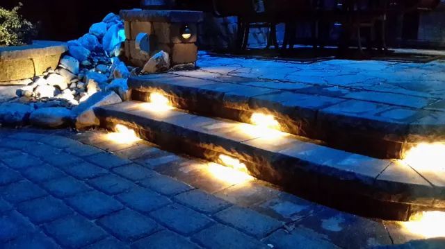 Stone steps lit by embedded lights at night.