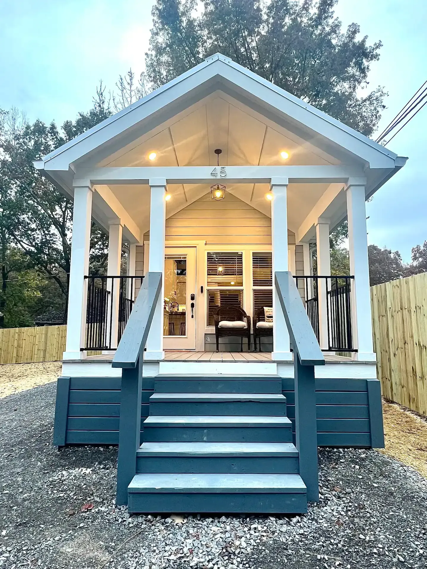 A small white house with a porch and stairs.
