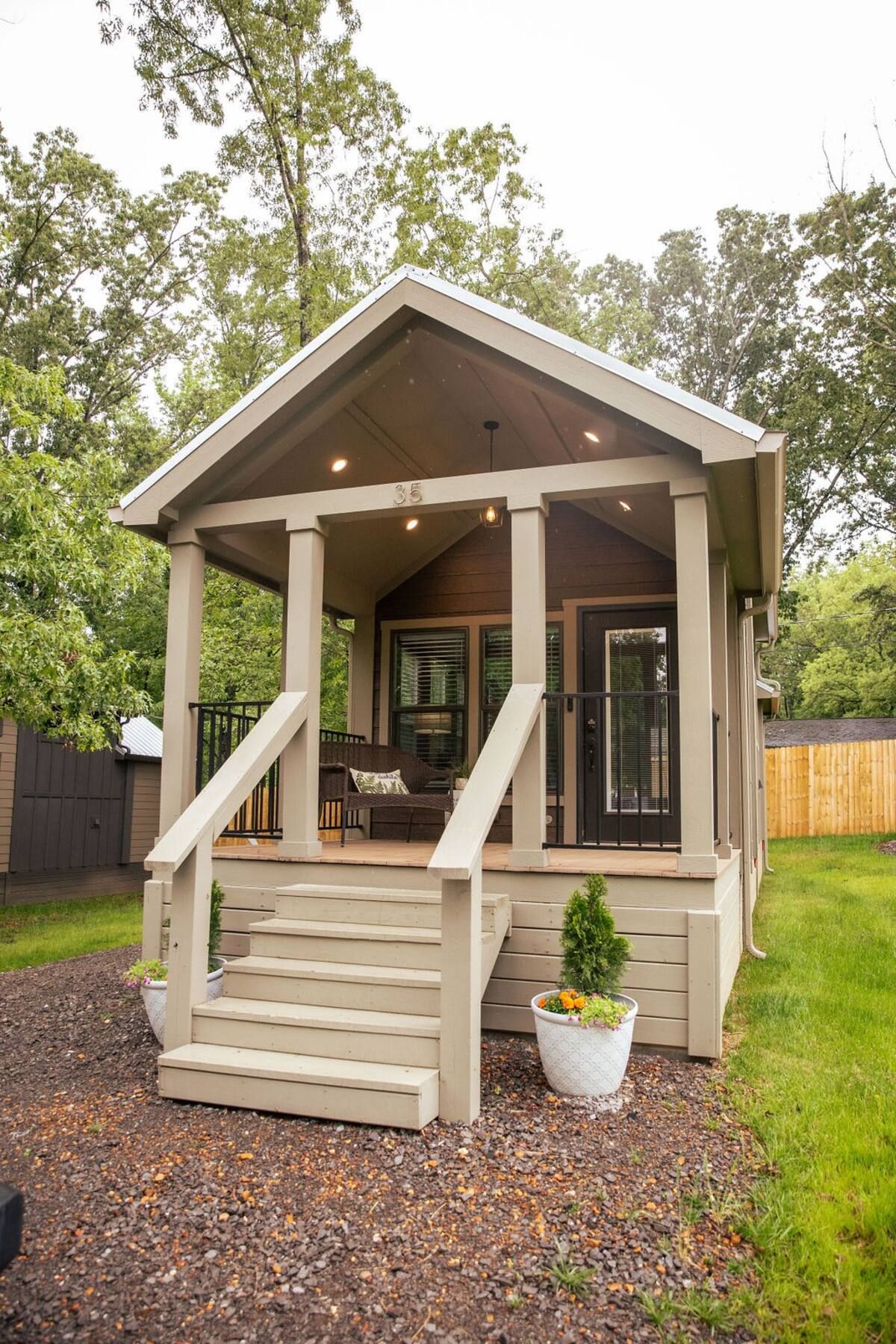 A small house with a porch and stairs in the backyard.