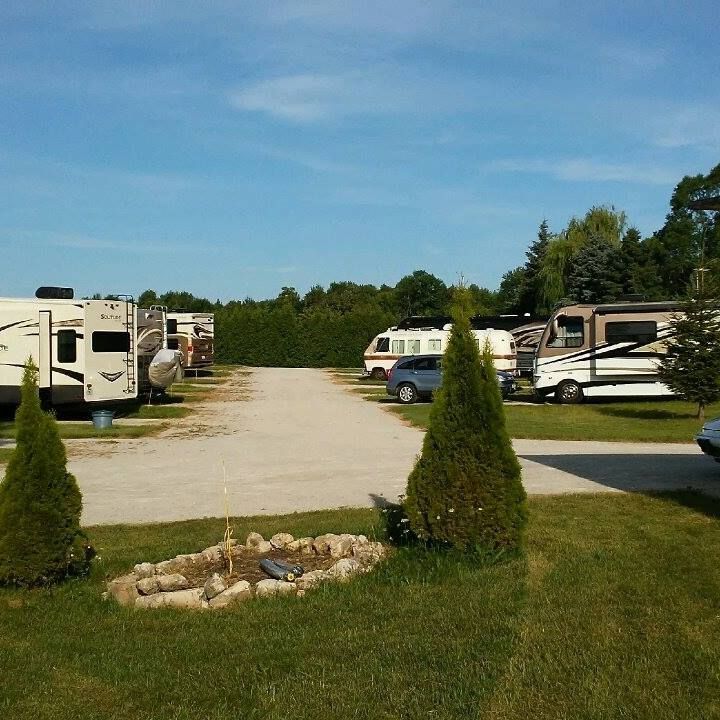 A row of rv 's are parked on a dirt road