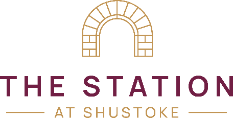 Logo for The Station at Shustoke, featuring a golden brick arch above burgundy text.