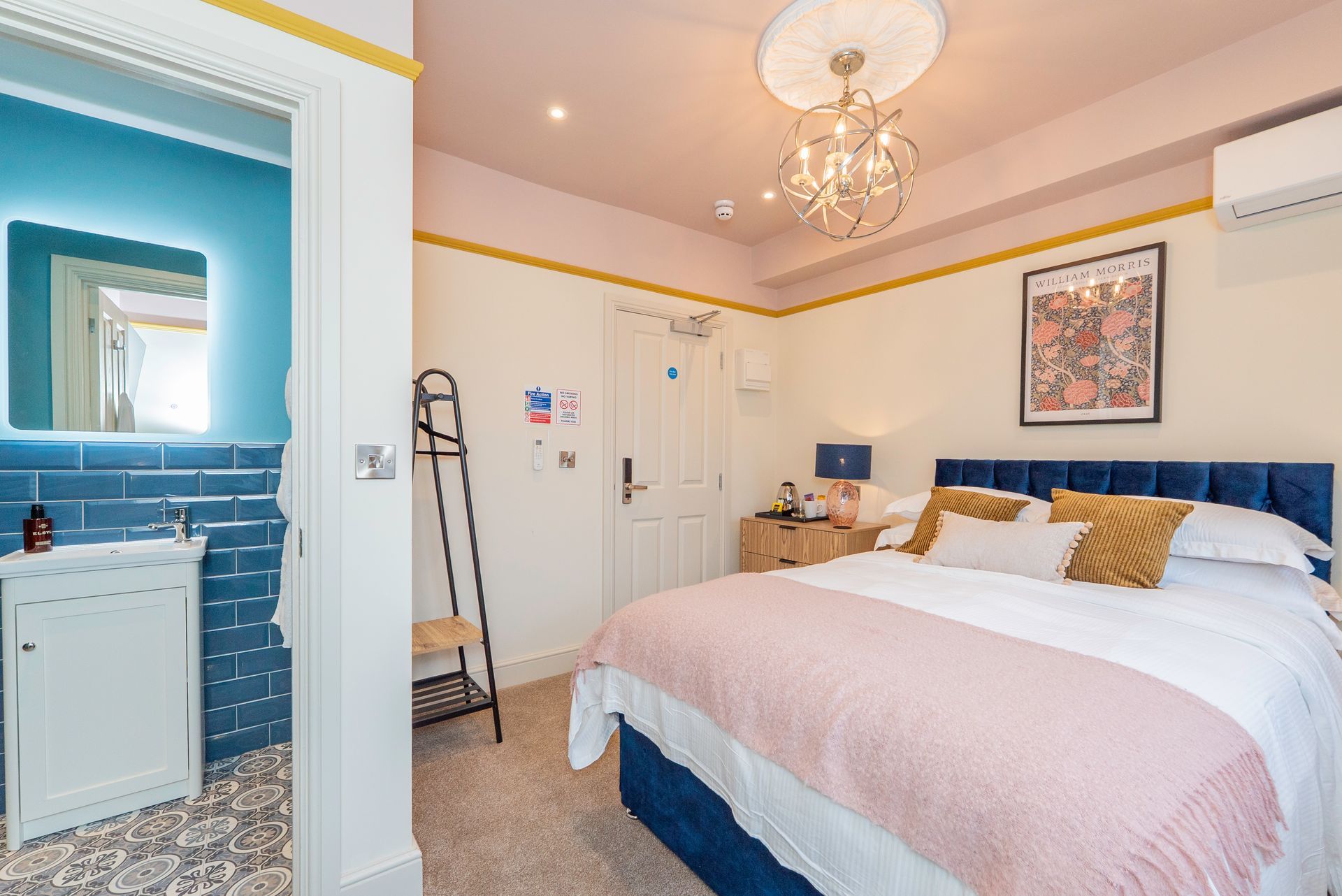 Bedroom with blue walls, pink ceiling, and a bathroom to the left.