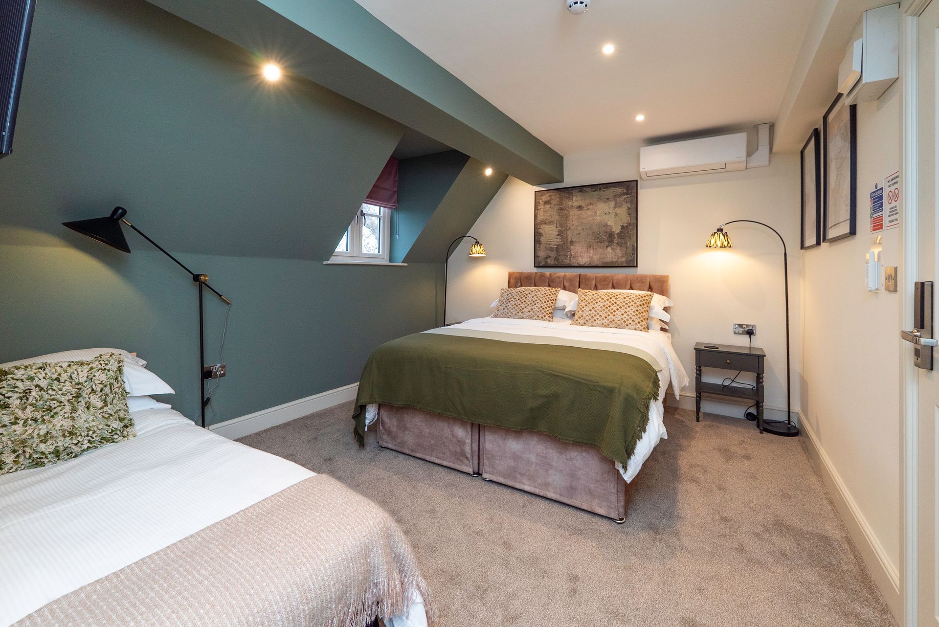 Hotel room with a queen-sized bed, twin bed, and olive-green walls.