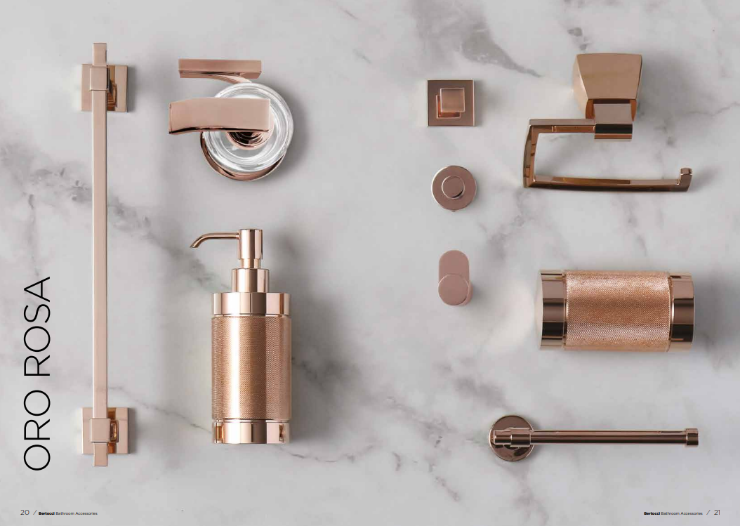 Una collezione di accessori da bagno color oro rosa, tra cui un portasciugamani, un dispenser di sapone e rubinetteria, su una superficie in marmo.