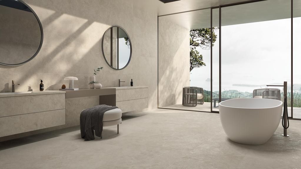 Un bagno moderno e minimalista con vasca freestanding, doppio lavabo con specchi rotondi e ampie finestre con vista.