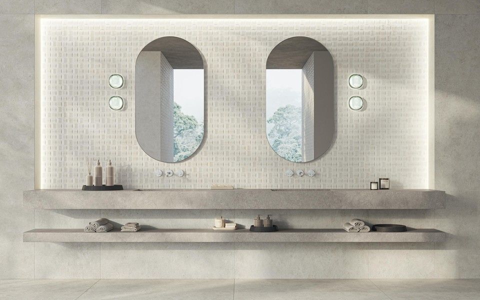 Un bagno minimalista con due specchi ovali, due mensole sospese in cemento e illuminazione d'accento a LED integrata.