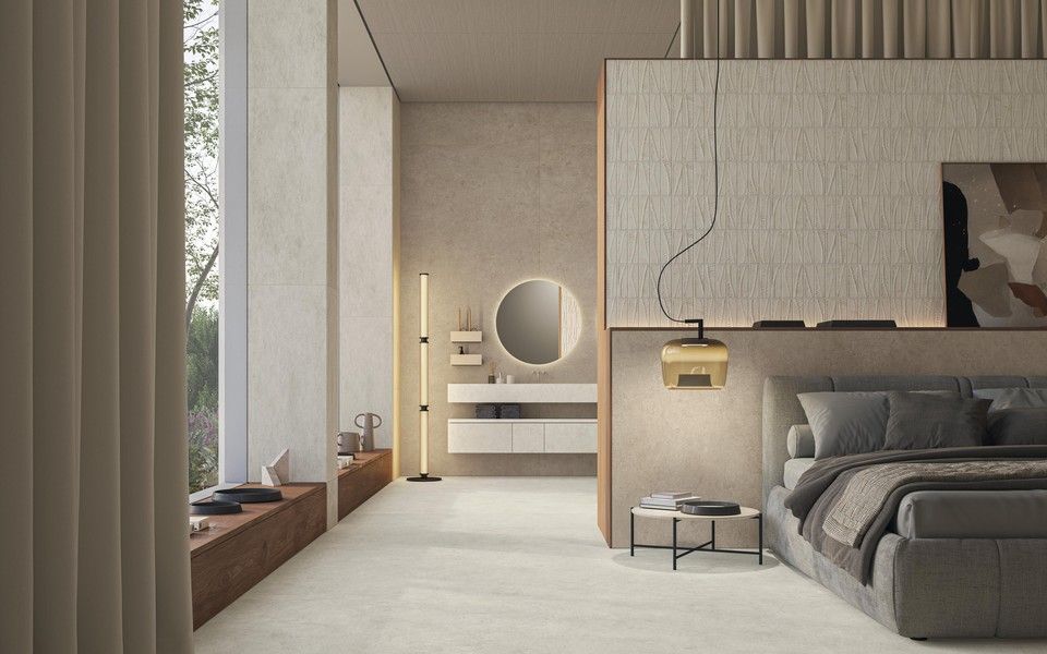 Una camera da letto moderna dai toni neutri, con letto imbottito grigio e bagno privato a pianta aperta.