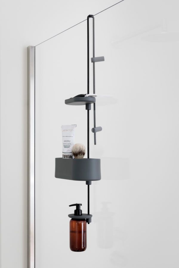 Un moderno portaoggetti da doccia di colore grigio scuro, da installare sopra il pannello in vetro, con ganci, ripiani e porta dispenser.