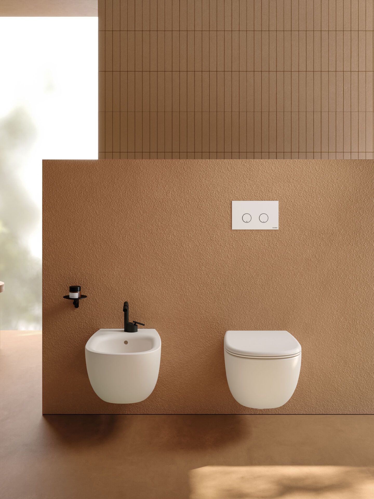 Bidet e WC a parete di colore bianco, con rubinetteria nera, su una parete marrone chiaro con finitura ruvida.
