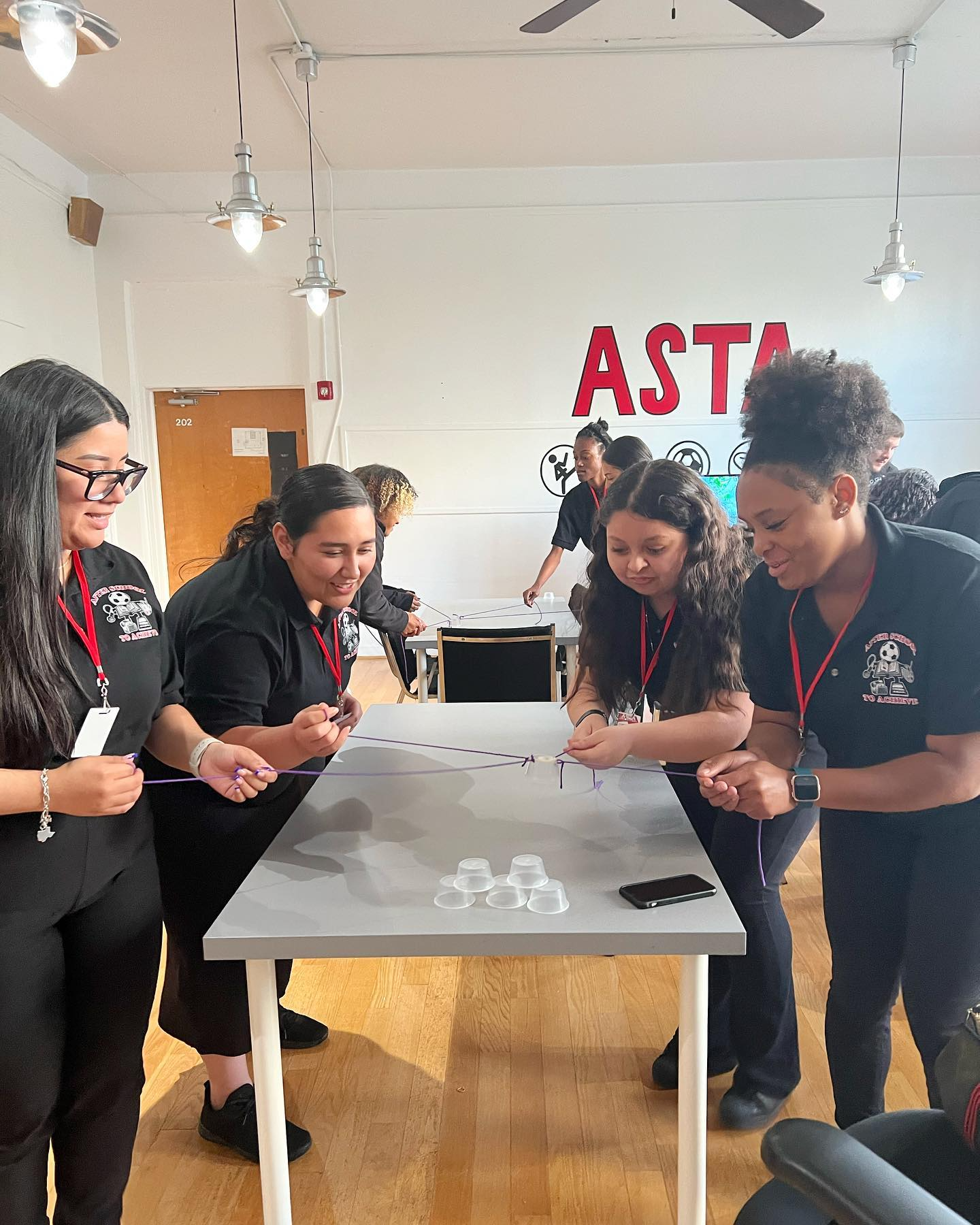 A group of women are standing around a table in a room.