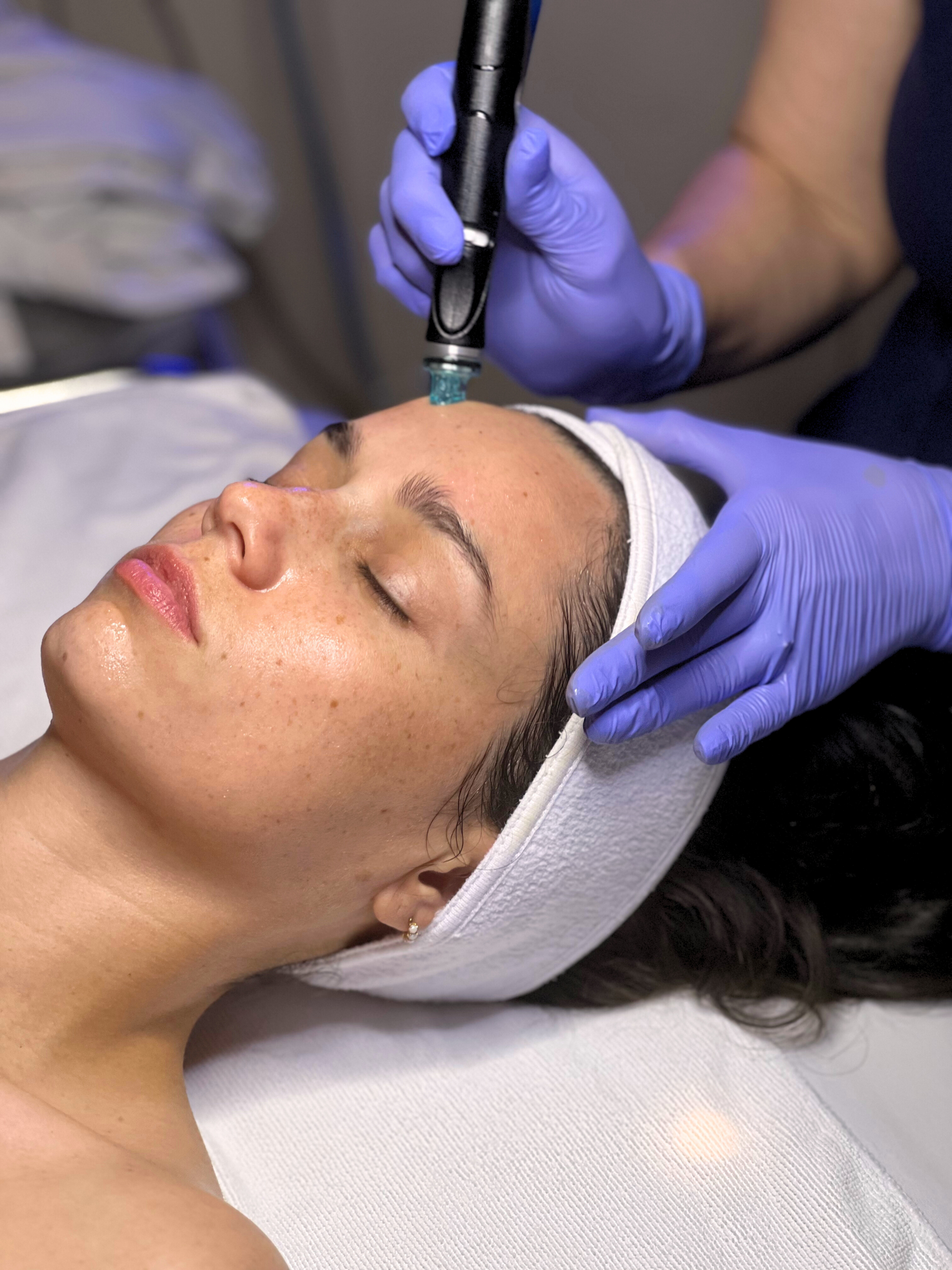 A woman is getting a facial treatment at a beauty salon.