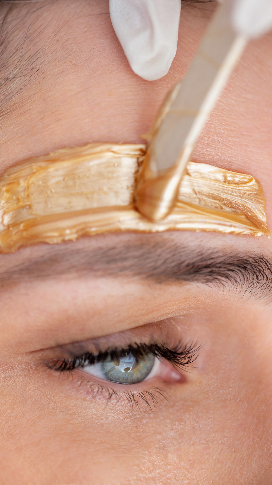 A woman is getting her eyebrows waxed in a beauty salon.