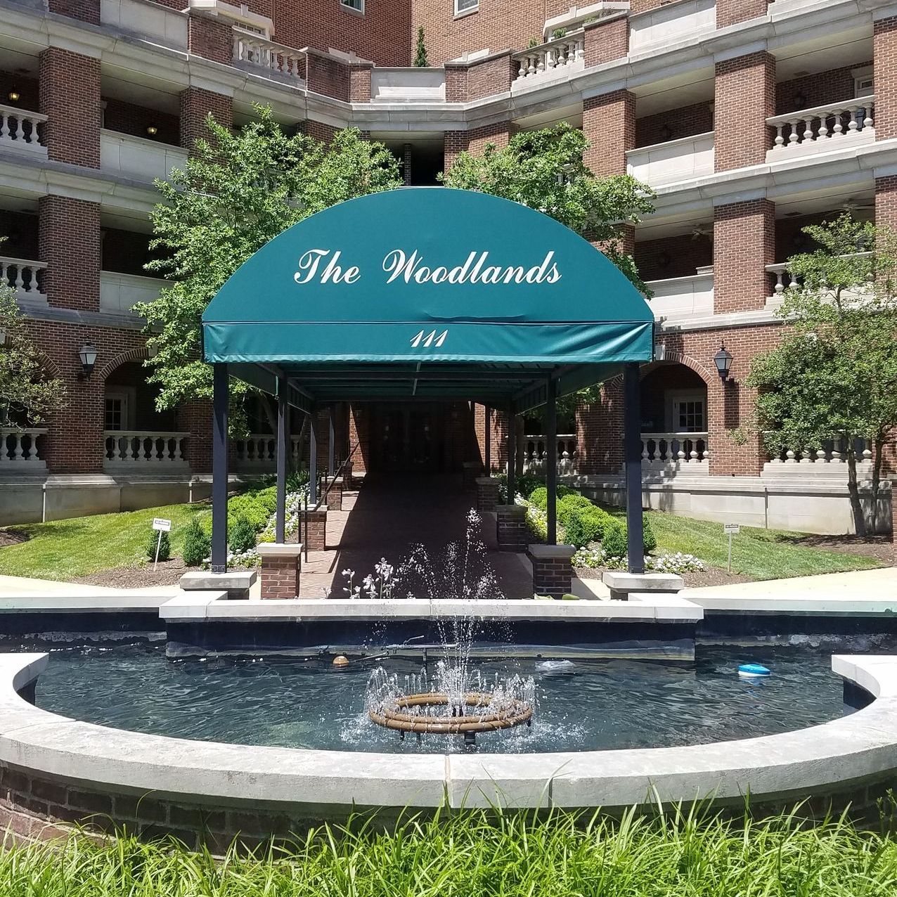 A fountain in front of a building that says the woodlands