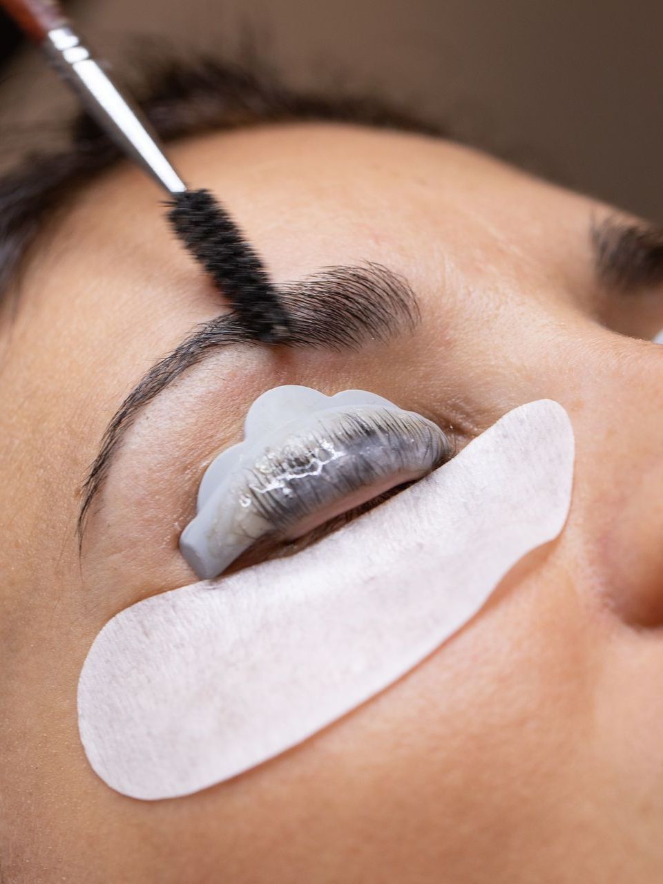 A woman is getting her eyelashes done at a beauty salon.