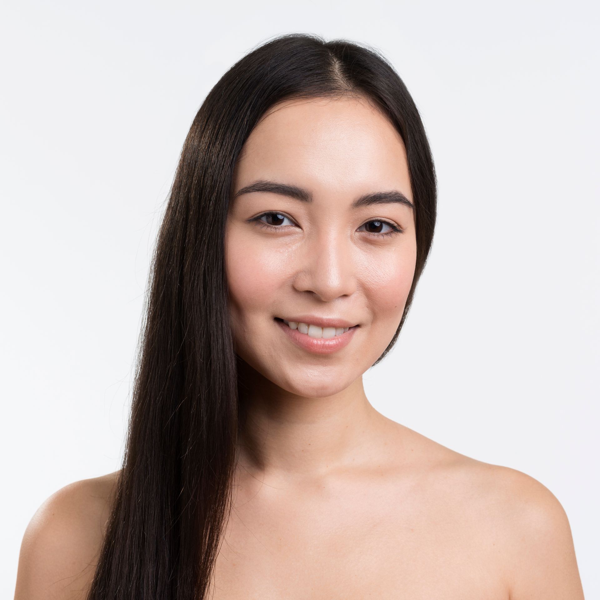A woman with long hair and no shirt is smiling for the camera.
