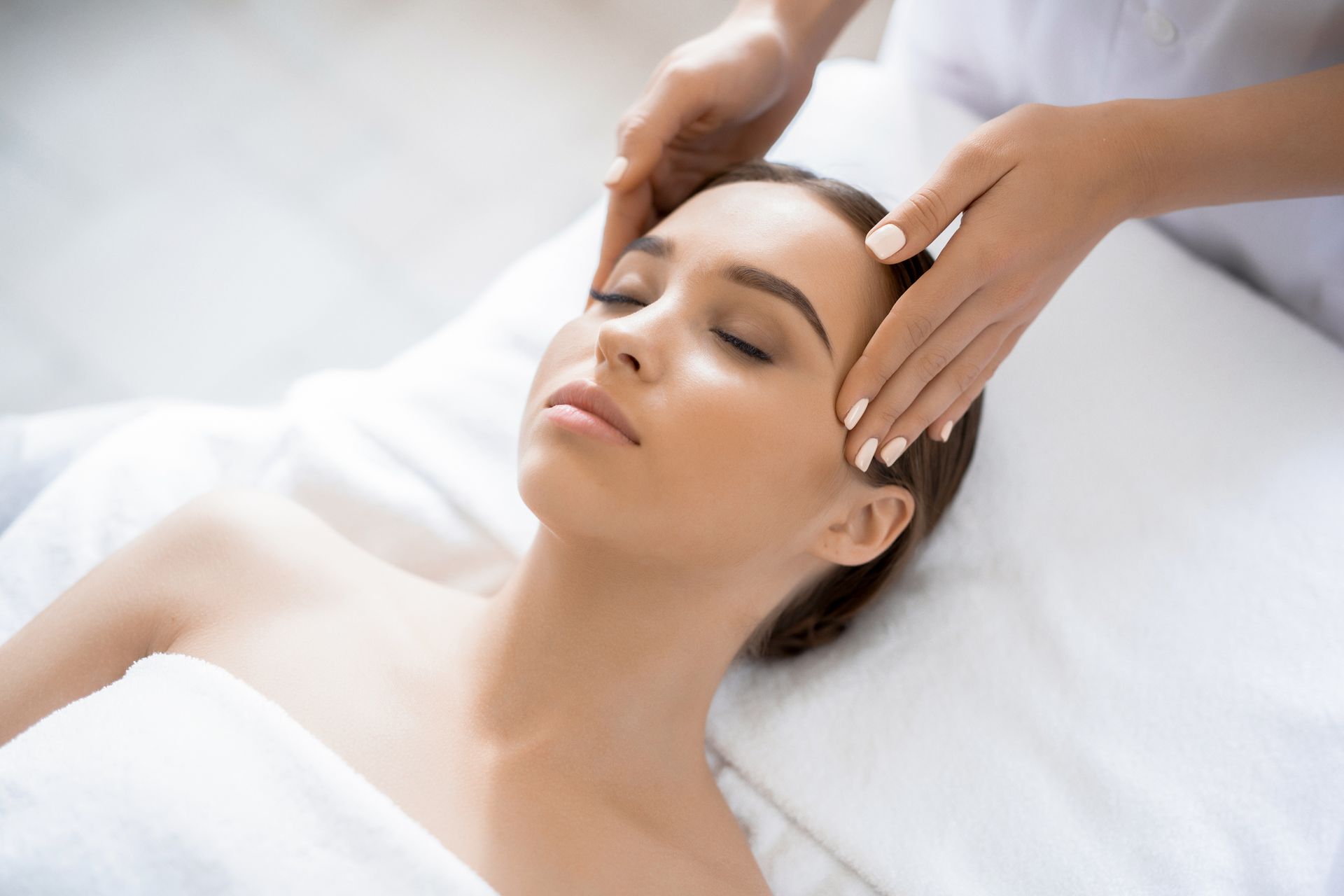 A woman is getting a head massage at a spa.