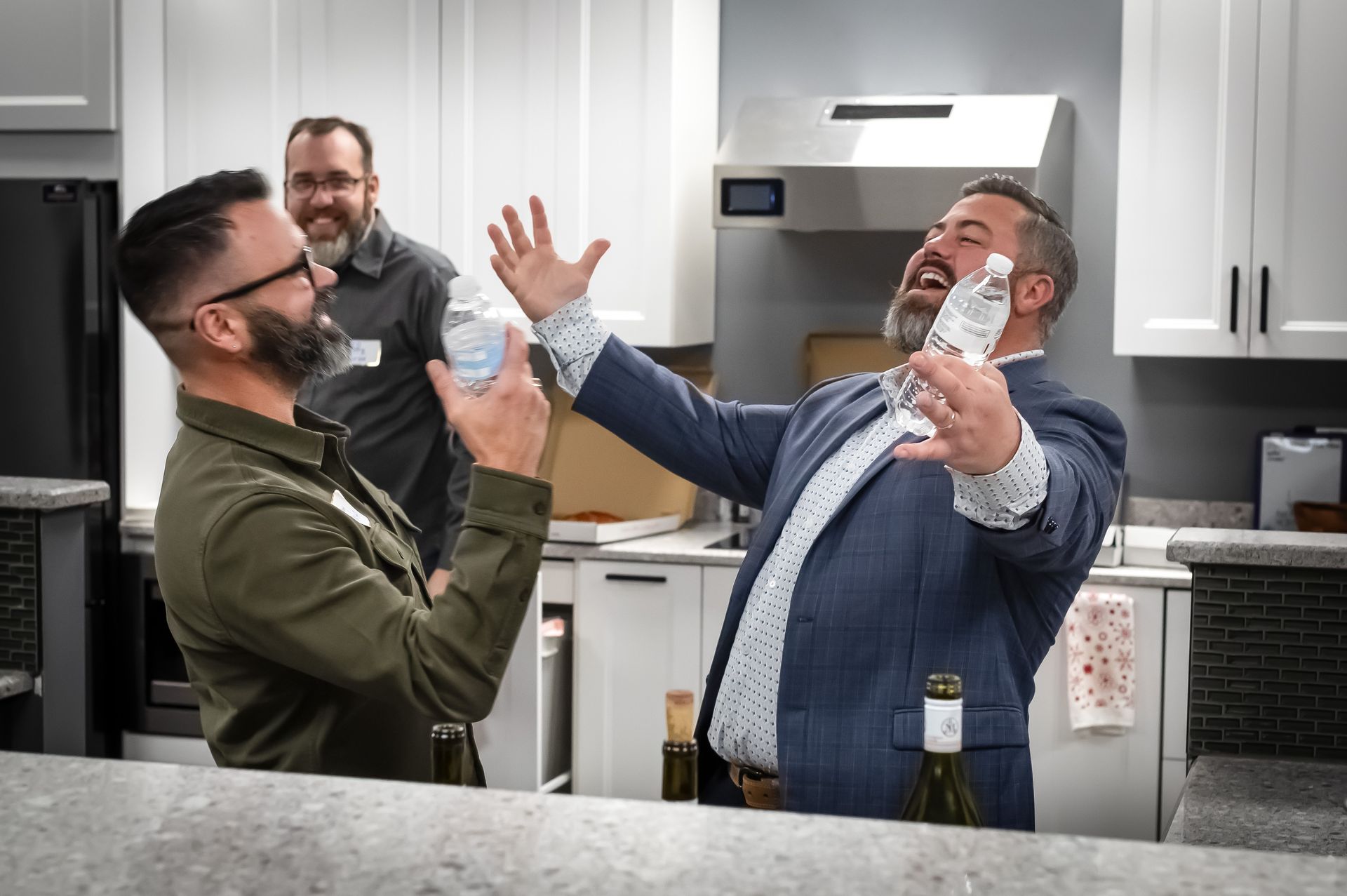 Two men standing in a kitchen engaged in conversation.
