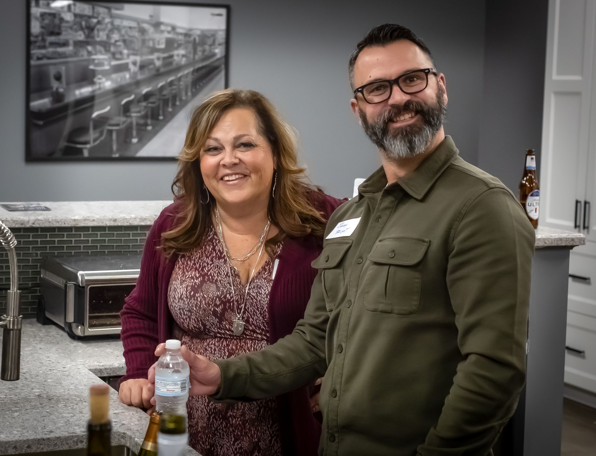 A man and a woman are standing next to each other in a kitchen.