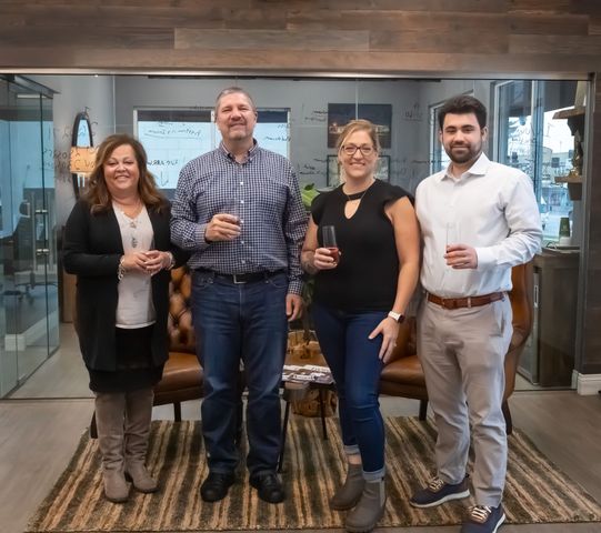A group of people standing next to each other holding wine glasses