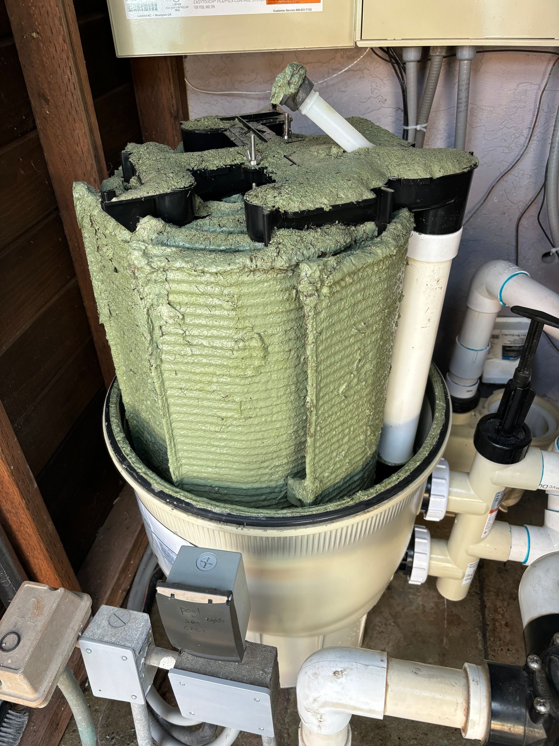 A dirty filter is sitting on top of a pile of pipes.