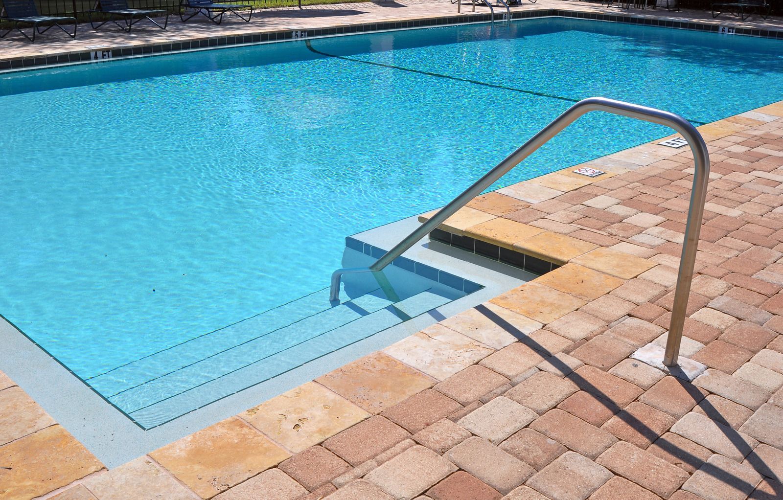 A large swimming pool with stairs leading to it