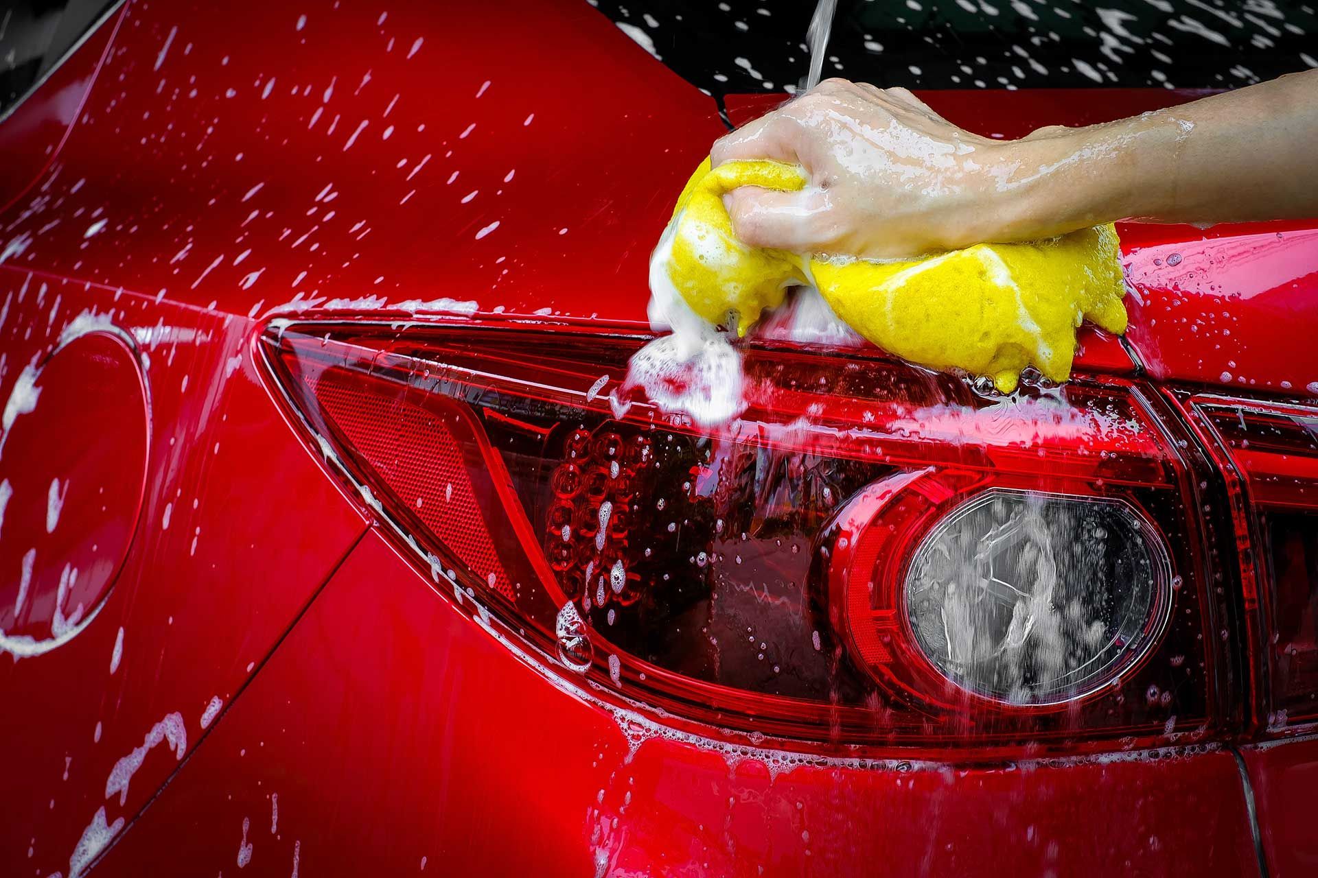 Wash a red car with copy space, can use for design. 
