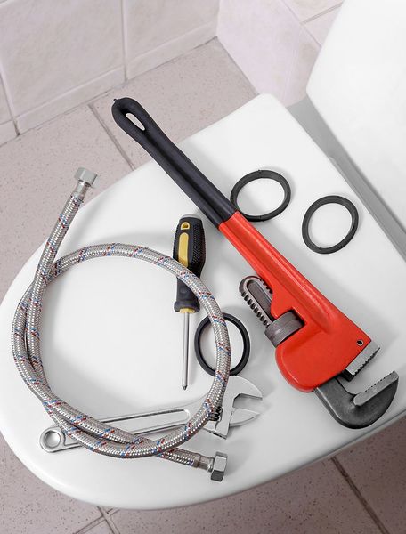A Toilet With A Wrench Hose And Screwdriver On It A Toilet With A Wrench Hose And Screwdriver On It