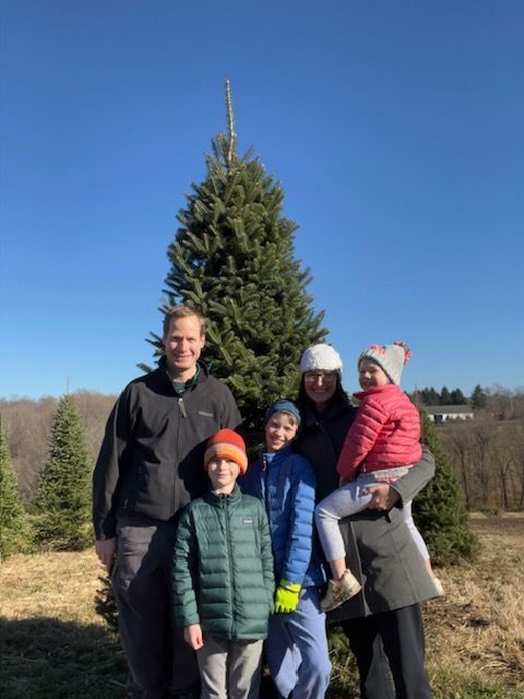 A family standing in front of a christmas tree