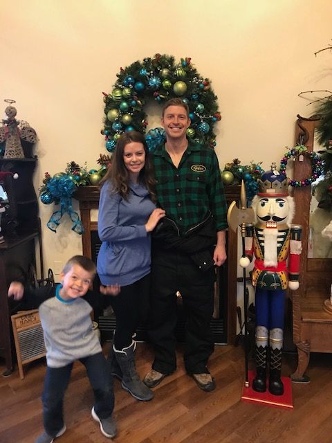 A family is posing for a picture in front of a nutcracker in a living room.