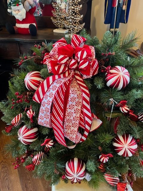 A christmas tree decorated with red and white candy cane ornaments and a bow.