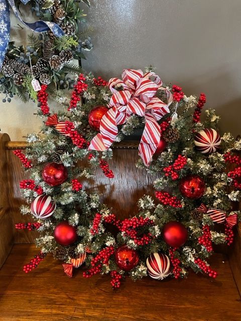 A christmas wreath is sitting on a wooden bench.